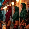 Four women in hijabs and lingerie pose on a city street at night.