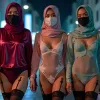 Three women in hijabs and masks wearing lingerie and stockings on a city street.